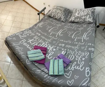 a bed with blankets and pillows on top of it at PePa in Petrovac na Moru