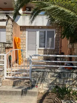 a fence in front of a house with a dog at PePa in Petrovac na Moru
