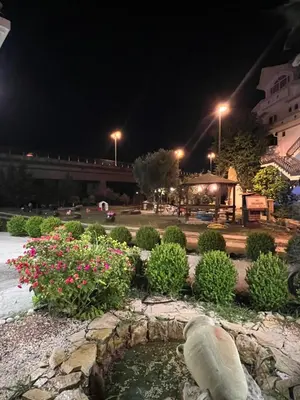 a pond in a park at night with flowers at Sunny apartments in Ulcinj
