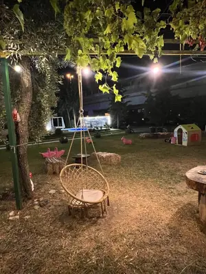 a swinging chair under a tree at night at Sunny apartments in Ulcinj