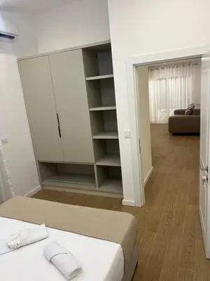 a bedroom with a bed and a closet and a couch at Sunny apartments in Ulcinj