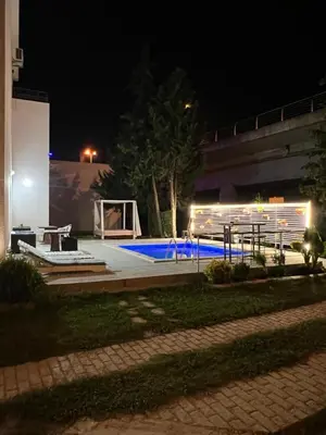 a swimming pool at night with a picnic table at Sunny apartments in Ulcinj