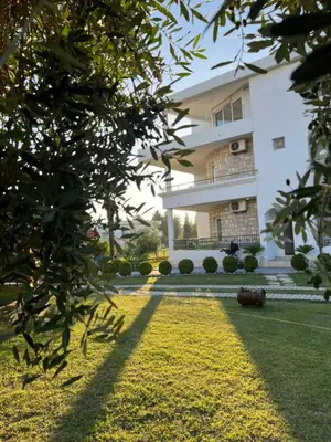 a large white building with a lawn in front of it at Sunny apartments in Ulcinj