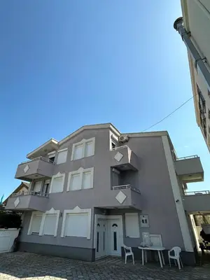 a building with two chairs in front of it at Stellax Apartment in Donji Štoj