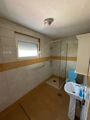 a bathroom with a sink and a toilet and a window at Stellax Apartment in Donji Štoj