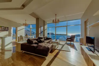 a living room with a large couch and a television at Hotel Tre Canne in Budva