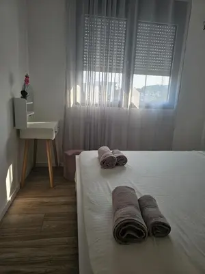 a bedroom with two towels on a bed with a window at SOL Apartment in Ulcinj