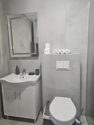 a bathroom with a toilet and a sink and a mirror at SOL Apartment in Ulcinj