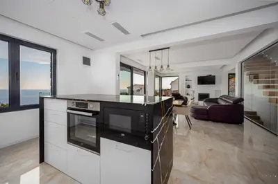 a kitchen with a stove top oven next to a living room at Villa Mare in Petrovac na Moru
