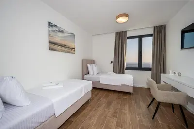 a hotel room with two beds and a desk at Villa Mare in Petrovac na Moru