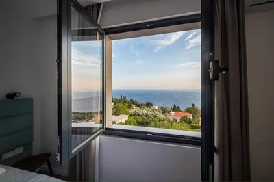 a view of the ocean from a bedroom window at Villa Mare in Petrovac na Moru