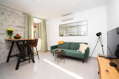 a living room with a green couch and a table at Dusan Residency in Kotor