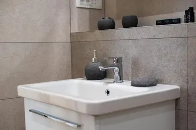 a bathroom sink with a soap dispenser on it at Dusan Residency in Kotor