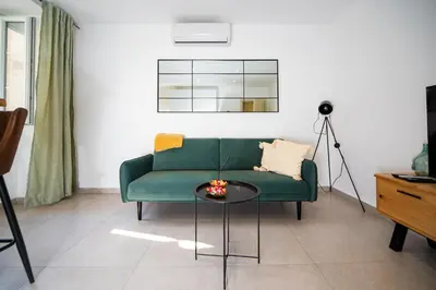 a living room with a green couch and a table at Dusan Residency in Kotor