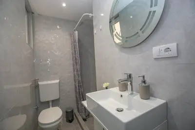 a bathroom with a sink and a toilet and a mirror at Vila Varagic in Budva