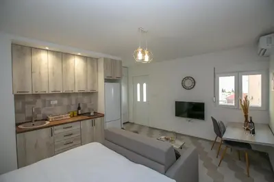 a kitchen and living room with a bed and a table at Vila Varagic in Budva