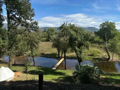 a view of a pond with a tent and trees at Zeta River Glamping in Danilovgrad