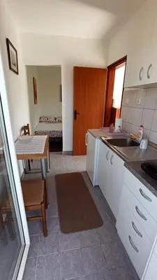a kitchen with a sink and a table with a bed at Urban Retreat Dalmatinska in Podgorica