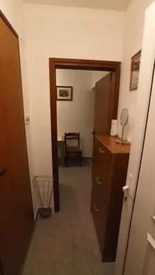 a hallway leading into a room with a dresser and a chair at Urban Retreat Dalmatinska in Podgorica