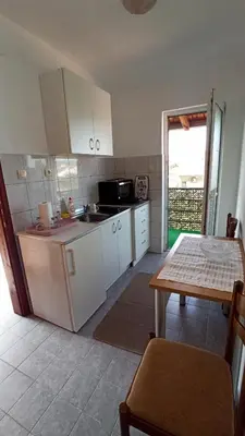 a kitchen with white cabinets and a table and a tableablish at Urban Retreat Dalmatinska in Podgorica