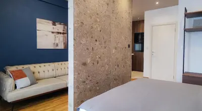 a bedroom with a bed and a couch in a room at Elegant Apartment with Urban Charm in Podgorica
