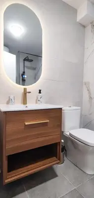 a bathroom with a sink and a toilet and a mirror at Elegant Apartment with Urban Charm in Podgorica