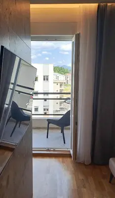 an open door to a balcony with a view at Elegant Apartment with Urban Charm in Podgorica