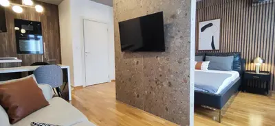 a bedroom with a bed and a tv on a wall at Elegant Apartment with Urban Charm in Podgorica
