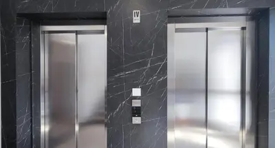 two elevators in a bathroom with black walls at Design Apartment with Panoramic Views in Podgorica