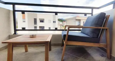 a chair and a table on a balcony with a window at Design Apartment with Panoramic Views in Podgorica