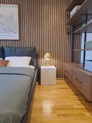 a bedroom with a bed and a dresser with a lamp at Design Apartment with Panoramic Views in Podgorica
