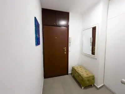 a hallway with a brown door and a green stool at Bar Centar Lux in Bar