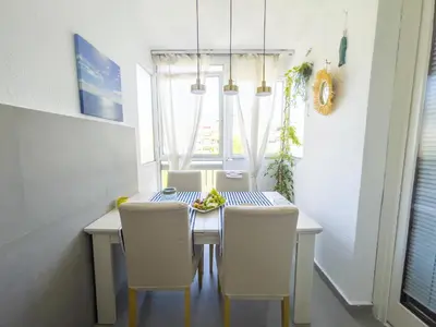 a dining room with a table and white chairs at Bar Centar Lux in Bar