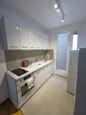 a kitchen with white cabinets and a sink and a refrigerator at Bar Centar Lux in Bar