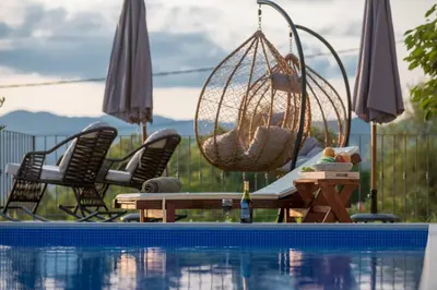 a hammock and chairs next to a swimming pool at Case del Tramonto in Kotor