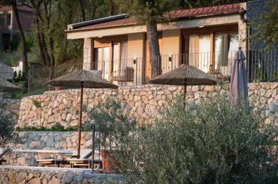 a stone wall with umbrellas in front of a building at Case del Tramonto in Kotor