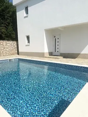a swimming pool in front of a white building at L U X V I L A, Dobre Vode in Dobra Voda