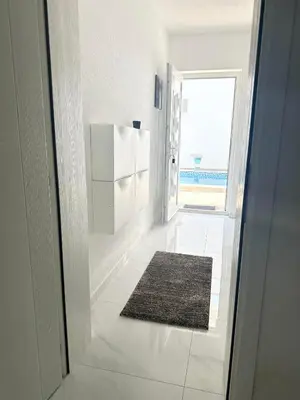 a hallway with a door and a rug on the floor at L U X V I L A, Dobre Vode in Dobra Voda