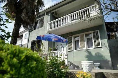 a house with a blue umbrella in front of it at Valdanos in Ulcinj