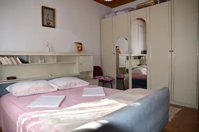 a bedroom with a bed with pink sheets and pillows at Valdanos in Ulcinj