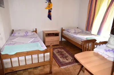 a room with three beds and a table and a table at Valdanos in Ulcinj