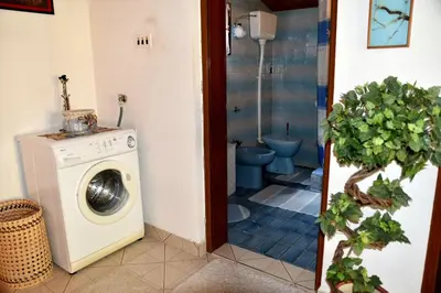 a bathroom with a washing machine and a toilet at Valdanos in Ulcinj