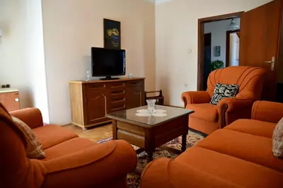 a living room with orange chairs and a tv at Valdanos in Ulcinj