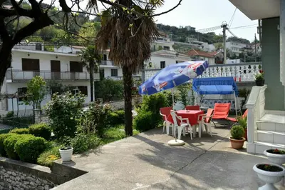 a patio with a table and chairs and an umbrella at Valdanos in Ulcinj