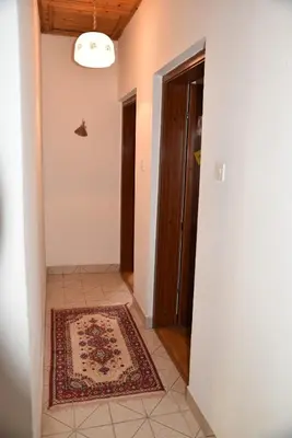 a hallway with a door and a rug on a floor at Valdanos in Ulcinj