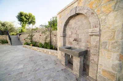 a stone sink on the side of a brick wall at Apartments Villa Bari in Ulcinj