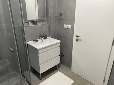 a bathroom with a white sink and a shower at Apartments Villa Bari in Ulcinj