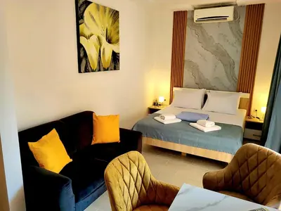 a hotel room with a bed and a couch and chairs at Aquamarine Jaz Montenegro in Budva