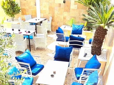 a group of blue chairs and tables on a patio at Aquamarine Jaz Montenegro in Budva