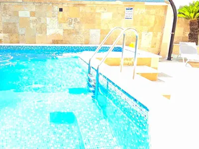 a swimming pool with blue water and stairs in it at Aquamarine Jaz Montenegro in Budva